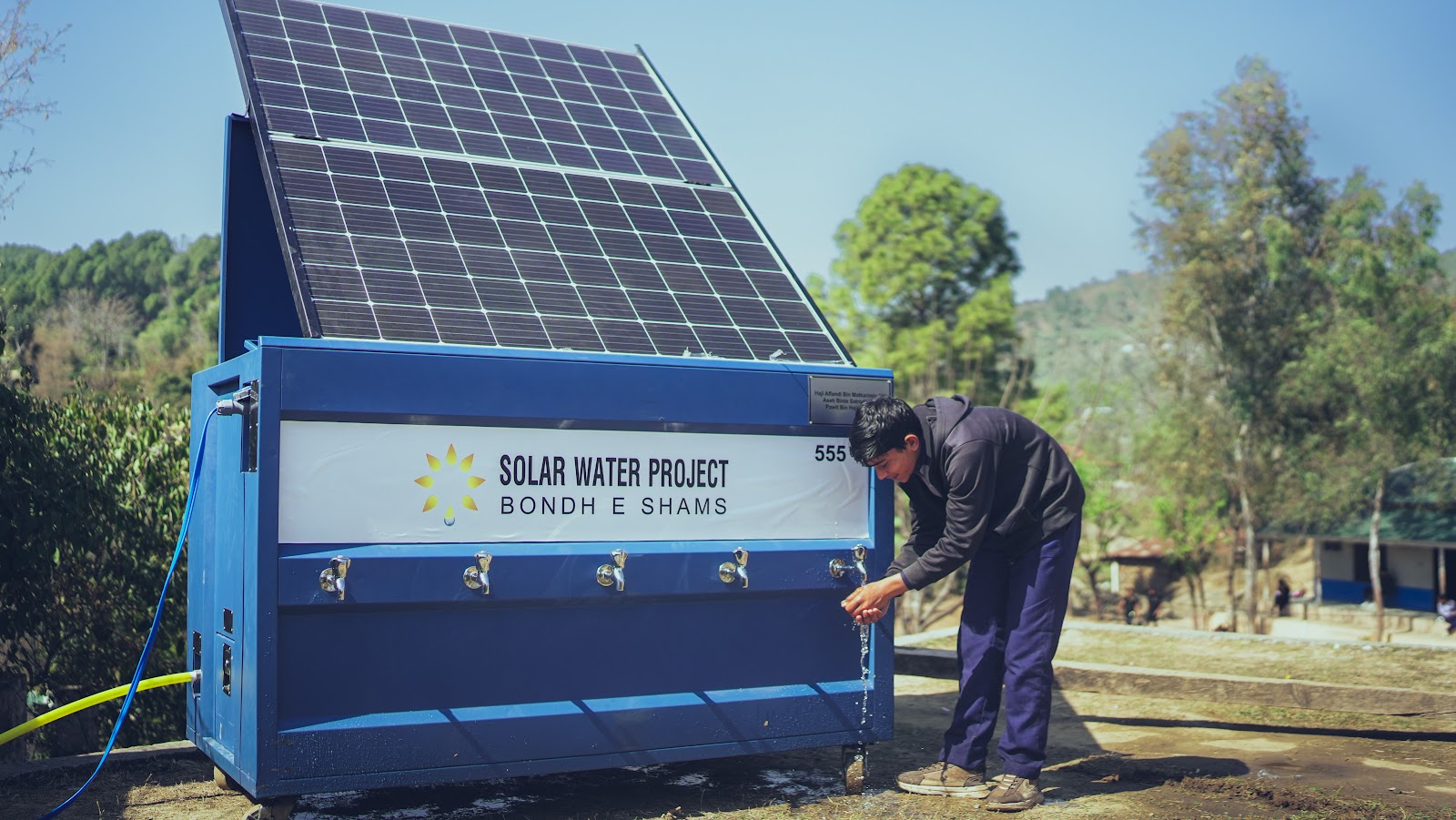 An OASIS Box unit with its solar panel dispensing water at a rural site